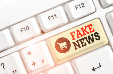 Text sign showing Fake News. Business photo text Giving information to showing that is not true by the media White pc keyboard with empty note paper above white background key copy space