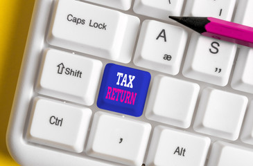 Text sign showing Tax Return. Business photo text which taxpayer makes annual statement of income circumstances White pc keyboard with empty note paper above white background key copy space