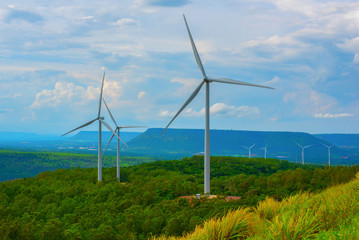 Beautiful landscape view of wind power turbine among mountain hill with blue sky in the early morning, Wind turbines on sunny morning, Windmills for electric power production, Green energy concept.