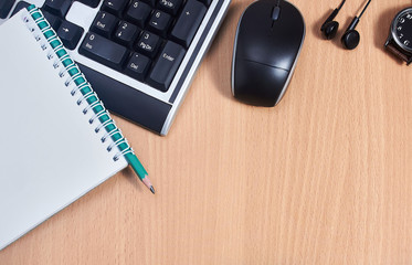 desktop with keyboard, clock, mouse. wooden background.