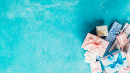 Holiday shopping. Top view of colorful jewelry boxes pile on aqua blue textured background. Copy...