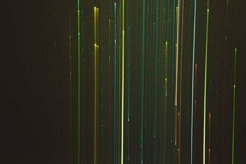 Blur neon multicolor lights. Illuminated vertical lines, falling sparkles. Dark abstract background.