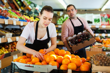 Female seller working with oranges