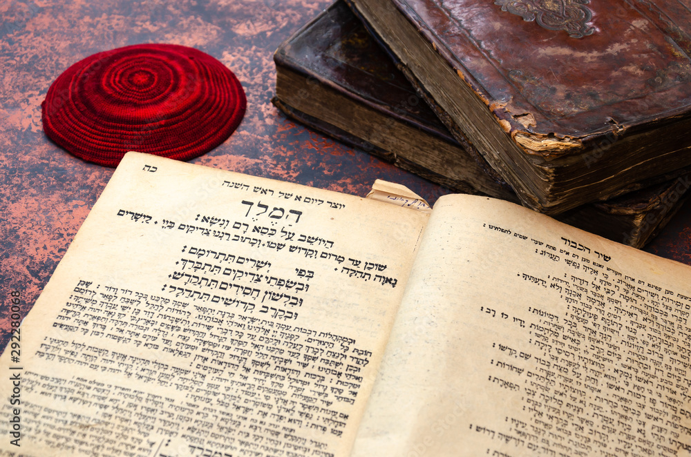 Poster jewish bible. a stack of old leather-bound jewish books with gold stamping and red knitted jewish ba - Posters