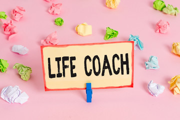 Conceptual hand writing showing Life Coach. Concept meaning A demonstrating who advices clients how to solve their problems or goals Colored crumpled papers empty reminder pink floor clothespin