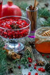 Warm cranberry tea with honey and pomegranate. Wood background.