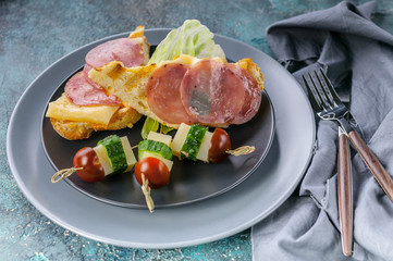 Delicious sandwiches, snacks, fast food, flour product. Bread pieces with stuffing. Breakfast on black plate. Fresh vegetarian nutrition. Gourmet meal