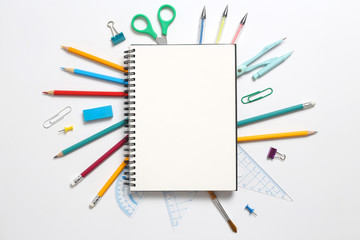 Top view, empty notebook and school supplies on a white background