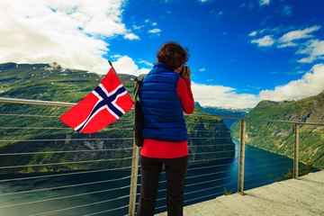 Tourist taking photo of fjord landscape, Norway