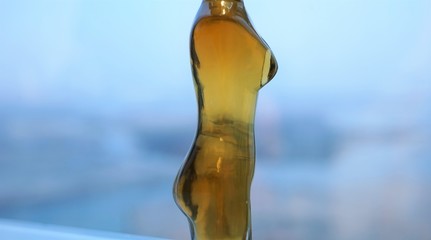 profile view of golden glass bottle in form of female body 
