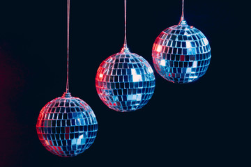 Sparkling disco balls hanging in the air against black background