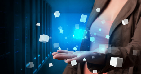 Person holding hologram projection displaying white cubes in server room