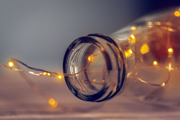 Lights garland in a glass bottle on a dark background