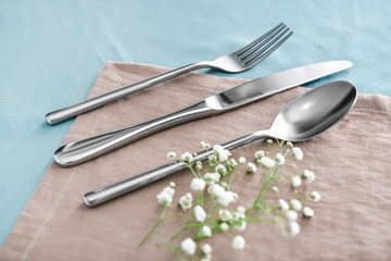 Clean cutlery with flowers on table