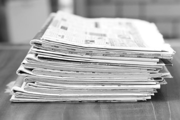 Big Pile of Newspapers on Wooden Table. Magazines and Journals Stacked in Heap. News Pages with Headlines and Articles in Office. Concept for Business and Media