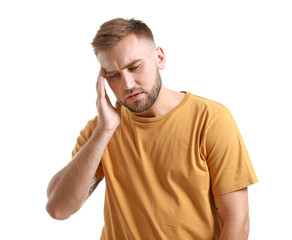 Young man suffering from headache on white background