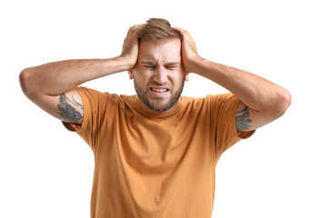 Young man suffering from headache on white background