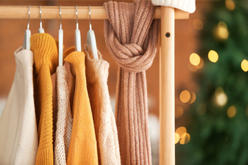 Rack with winter clothes at home on Christmas eve