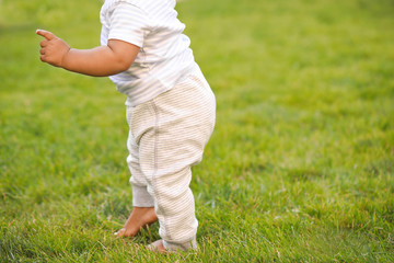 Cute little baby learning to walk outdoors