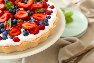 Stand with tasty berry pie on table, closeup