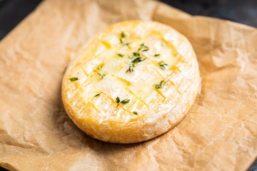 Baked camembert cheese with thyme on the rustc background. Selective focus. Shallow depth of field.