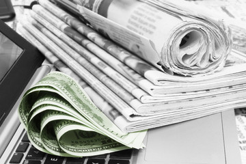 Stack of Newspapers, Money and Laptop. Journals with Headlines and Articles and One Hundred Dollar...