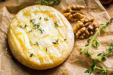 Baked camembert cheese with figs, walnuts, honey and thyme on the rustc background. Selective focus. Shallow depth of field.