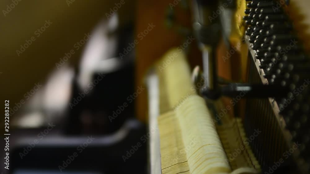 Poster changing keys and tuning a piano by hand in a shop.