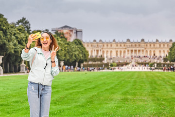 Happy girl travels to Versailles and admires the wonderful view of the Palace and garden