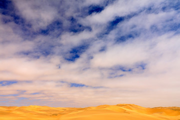 Blue sky with sand dune. Landscape in Namibia, Africa. Travelling in the desert. Yellow sand hills. Namib Desert, sand dune mountain with beautiful blue sky with white clouds.