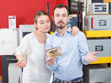 Upset girl with boyfriend looking for new reliable door lock in store