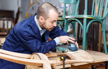 Restorer in process of renovation vintage armchair