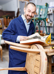 Craftsman looking at album in workshop