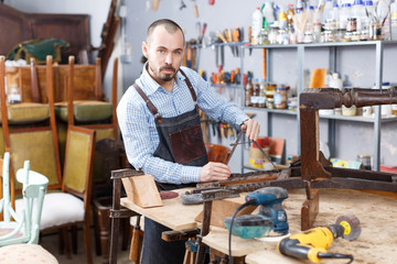 Carpenter repairing antique chair