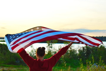 Woman with american flag in the evening at sunset.