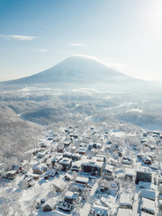 Winter in Niseko, Japan. A blue bird kind of day at Grand Hirafu, Niseko Ski Resort. Photos were taken with a drone overlooking the Grand Hirafu area with views of Mt. Niseko-Annupuri. and Mt. Yotei.