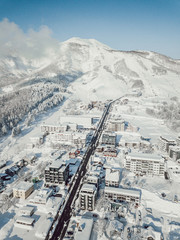 Winter in Niseko, Japan. A blue bird kind of day at Grand Hirafu, Niseko Ski Resort. Photos were taken with a drone overlooking the Grand Hirafu area with views of Mt. Niseko-Annupuri. and Mt. Yotei.