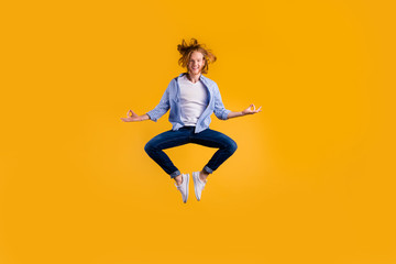 Fototapeta na wymiar Full length photo of redhead handsome guy jumping high meditating exercise holding body in lotus position wear casual trendy clothes isolated yellow background