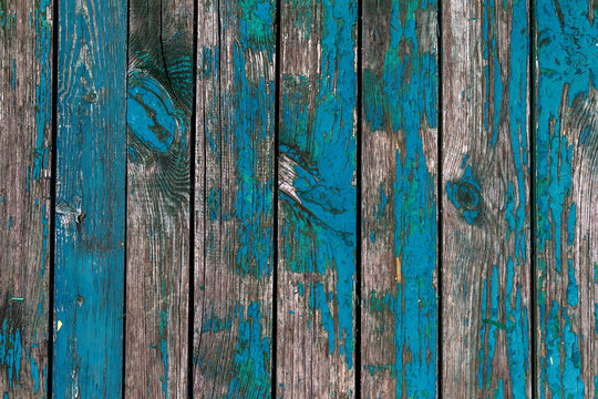 Old shabby wooden boards with cracked paint, background. Background old wood with large cracks and traces of the remains of old paint