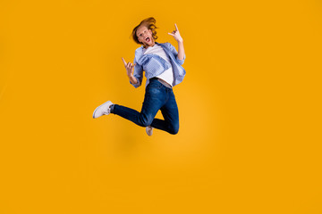 Fototapeta na wymiar Full length photo of crazy redhead guy jumping high making horns with fingers excited to visit favorite band concert wear casual outfit isolated yellow background