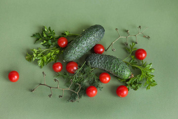 Naklejka na ściany i meble Flat lay composition with fresh cucumber, green-stuff and tomatoes on green background with copy cpace