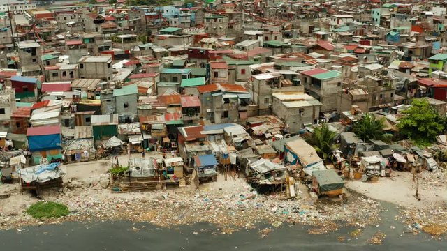Slums in Manila, a top view. Sea pollution by household waste. Plastic trash on the beach.