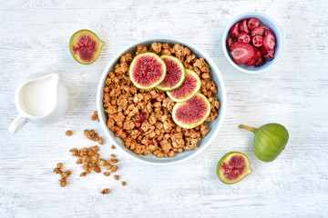 Granola for healthy breakfast. Bowl with granola and fresh fig and dried berries, top view