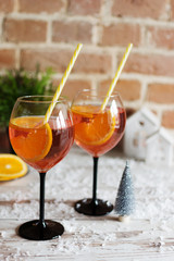 Two glasses of rossini prosecco cocktail with orange slices on wooden background.