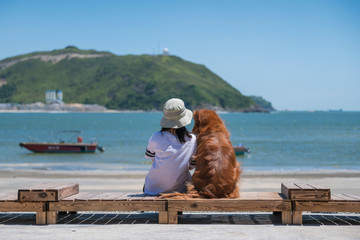 Golden Retriever with the owner sunbathing by the sea
