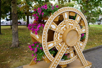 Fototapeta premium Flower bed made of wood in wheel shape. close up photo
