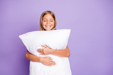 Portrait of positive cheerful kid enjoy bed time hug embrace her pillow have weekends nap feel...