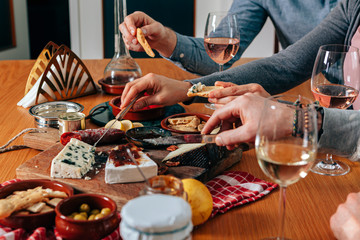 hands picking up and cutting delicattessen from a table prepared with gourmet finger food