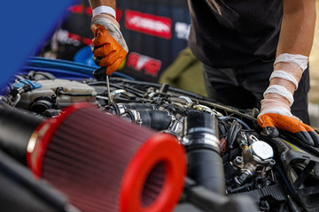 Automobile mechanic repairing a car engine. man fixing the engine car. service and maintenance.