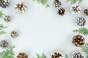 Christmas winter decoration made from green branches and pine cones on snow texture background. Flat lay frame mockup